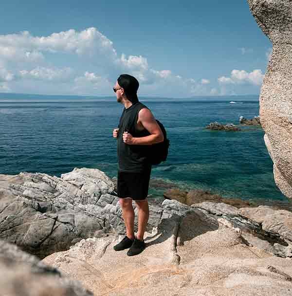 Άνδρας που ατενίζει τη θάλασσα από τη βραχώδη ακτή