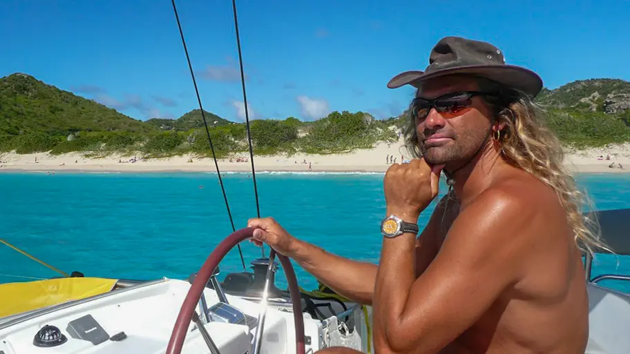 Meet your skipper Willi Ewig on board of the Sunrise with beach in the background